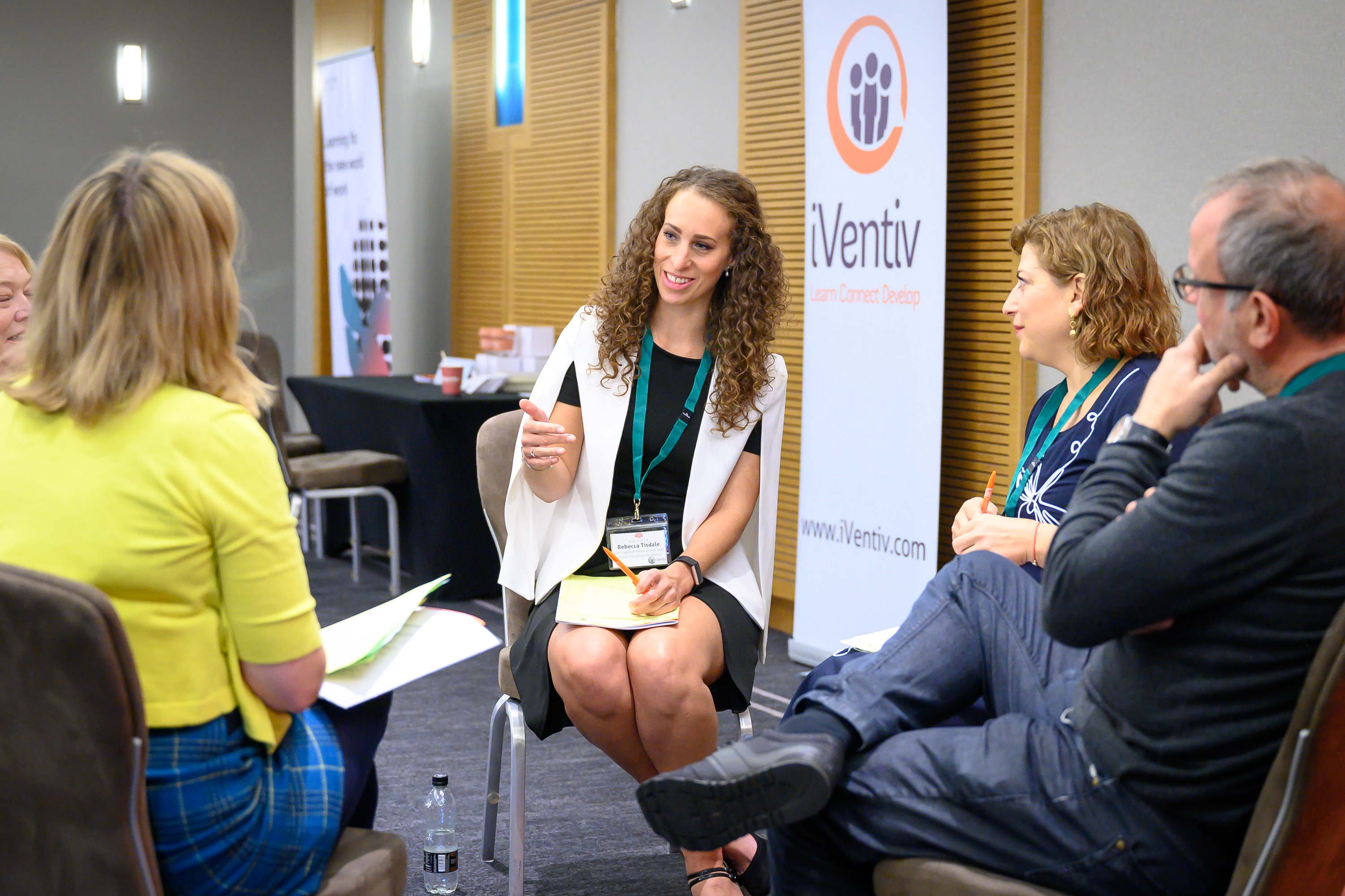 Participants smiling and talking during a breakout session at an iVentiv event