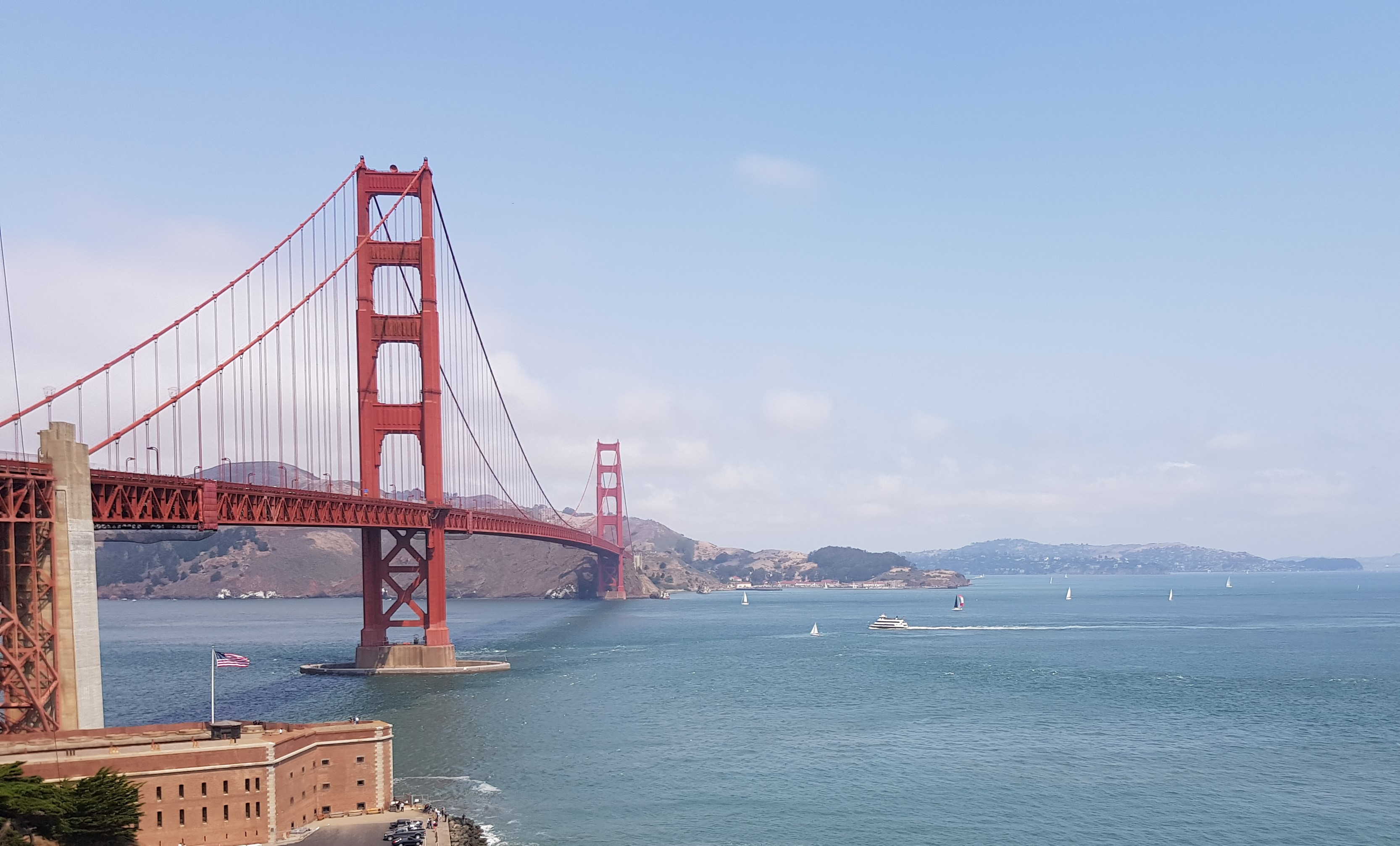 A view of the bright red golden gate bridge in San Francisco on a sunny day.